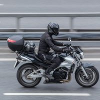 Motorcycle safety. Motorcyclist in a helmet rides a motorcycle on the road.