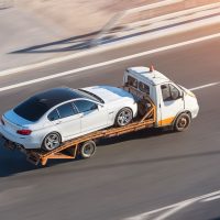 Recovery truck to transport a car on the highway in the city.